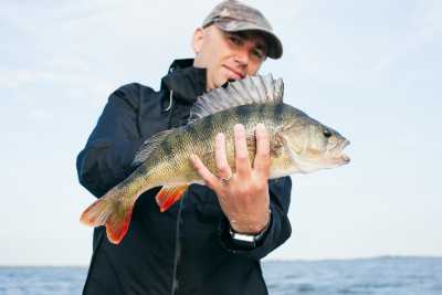 Man proudly holding large fish just caught.