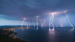 Several lightning bolts over body of water